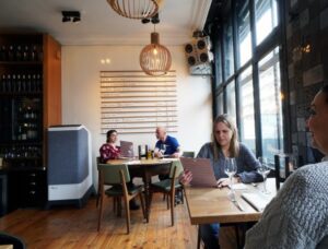People sitting in a cafe with Euromate Pure Air's best air purifier in Australia installed on a side